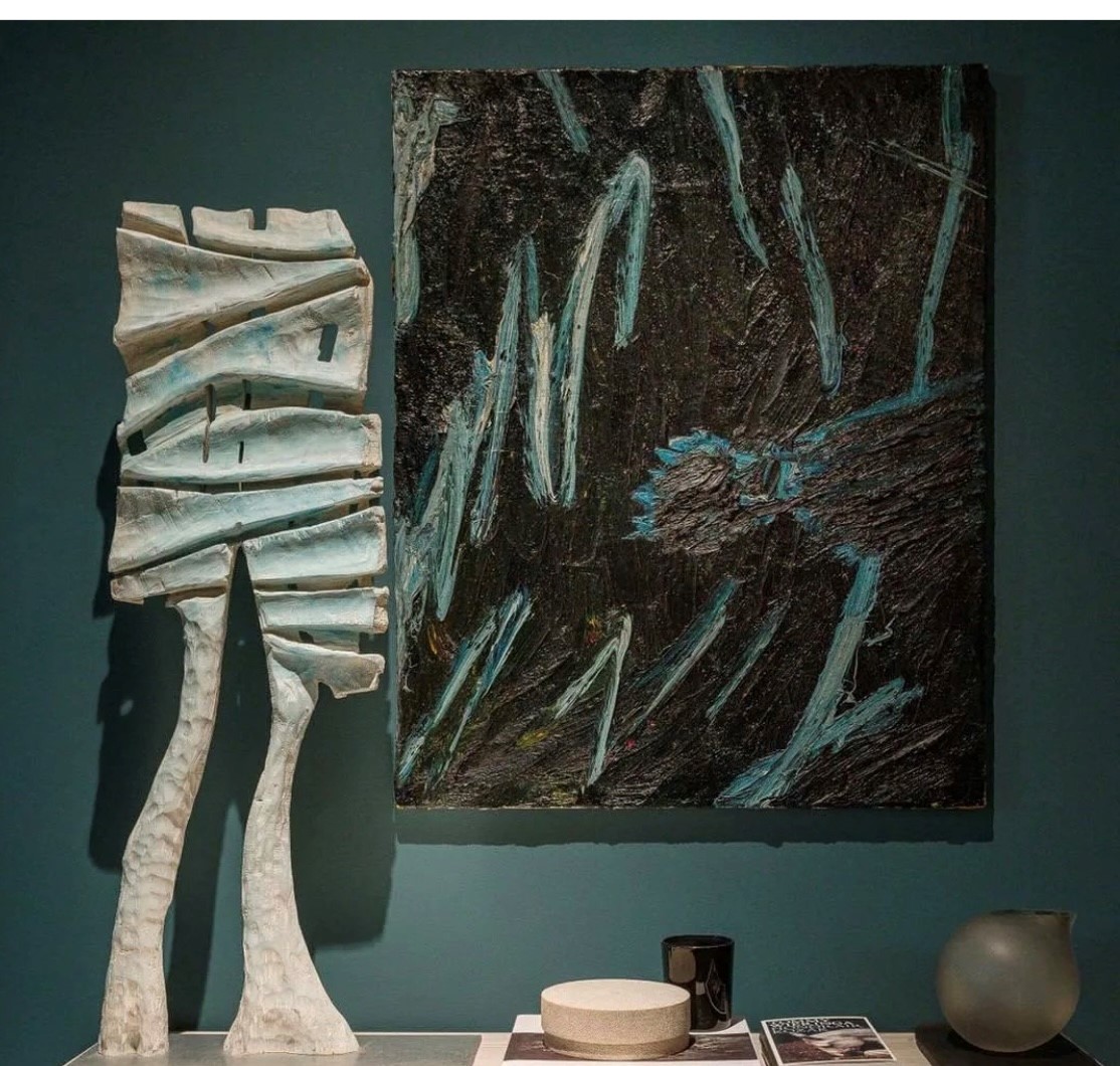 Houtsculptuur naast een schilderij